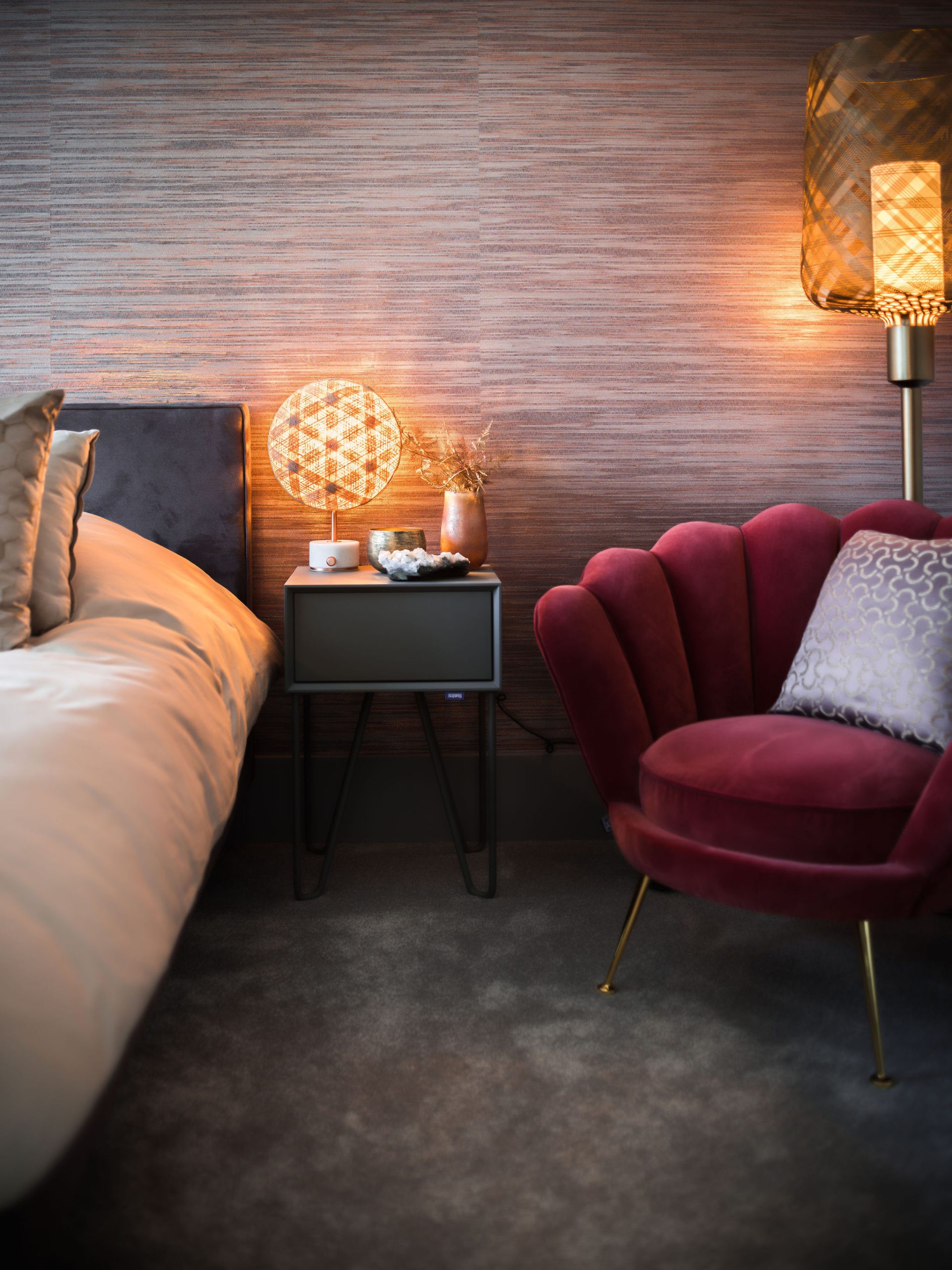 zithoekje in meidenkamer met een rode fluwelen schelpvormige fauteuil, een vloerlamp en styling op het grijze nachtkastje