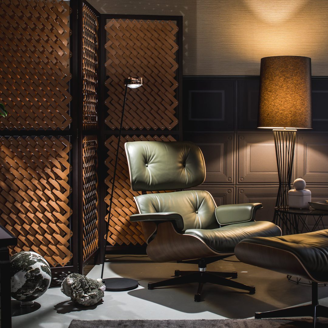 Zithoek met design klassieker fauteuil van Charles and Ray Eames, cognac kleurig leren room divider en stalen vloerlamp met lampenkap